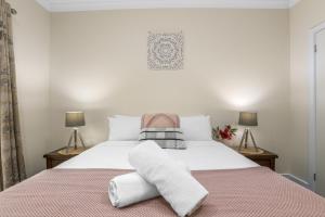 a bedroom with a large white bed with two lamps at Galbraith Beach Studio 1 - steps away from beach in Marengo