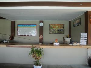 a counter in a restaurant with a clock on the wall at Surf Garden Lombok in Bumbang