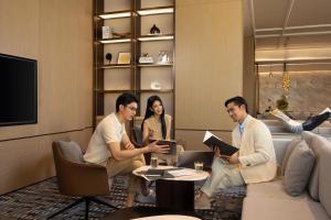 eine Gruppe von Menschen, die in einem Raum um einen Tisch herum sitzen in der Unterkunft Courtyard by Marriott Xiamen Xiang’an in Xiamen + 19 Fotos