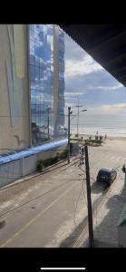vista su una strada con un edificio e un'auto di Apartamento compartilhado na quadra do mar a Itapema