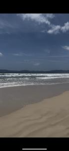 una spiaggia deserta con l'oceano sullo sfondo di Apartamento compartilhado na quadra do mar a Itapema
