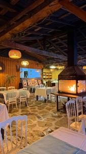 een restaurant met witte tafels en stoelen en een open haard bij Gızlıkoyhotel in Antalya
