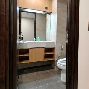 een badkamer met een wastafel en een toilet bij Saffron Noble Apartment in Citaringgul 1 +9 foto's