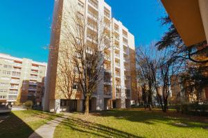 un edificio alto con un albero di fronte di PrimoPiano - Sporting Mirasole a Opera