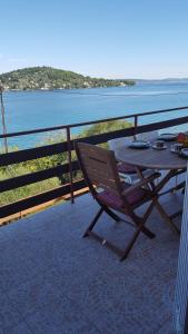 a wooden table and chair on a balcony overlooking the water at Apartment Ana in Kali
