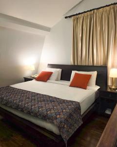 una camera da letto con un letto grande con due cuscini rossi di Via Mina Hotel a El Mîna