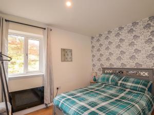 a bedroom with a bed and a window at Faodail House in Portree