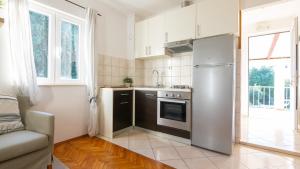 a kitchen with a stainless steel refrigerator and a couch at House Rilovic by Villas Guide in Srednji Radovčići