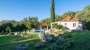a small house in a yard with a swimming pool at House Rilovic by Villas Guide in Srednji Radovčići