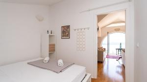 a white bedroom with a bed and a window at Grand view Orasac by Villas Guide in Dubrovnik