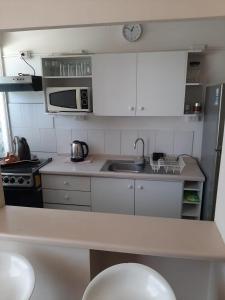 a small kitchen with a sink and a microwave at Galicia in La Serena