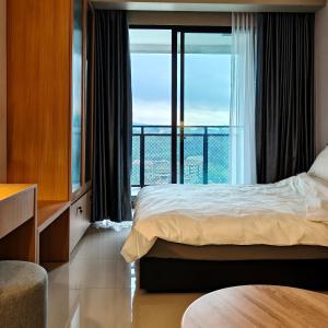 een slaapkamer met een bed en een groot raam bij Saffron Noble Apartment in Citaringgul 1