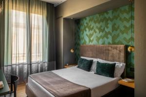 a hotel room with a bed and a green wall at Re Sale Boutique Hotel in Trapani