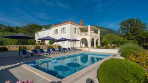 a villa with a swimming pool in front of a house at Cypress Paradise by Villas Guide in Dubravka