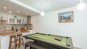 a pool table in a kitchen with a bar at Cypress Paradise by Villas Guide in Dubravka