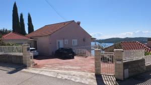 una casa rosa con una recinzione di fronte di Apartman Helen Orasac by Villas Guide a Poljice