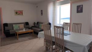 una cucina e un soggiorno con un tavolo e un divano di Apartman Helen Orasac by Villas Guide a Poljice Altre 17 foto