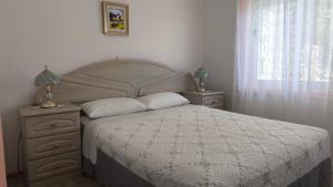 una camera da letto con un grande letto con due comodini e due lampade di Apartman Helen Orasac by Villas Guide a Poljice