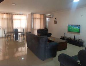 een woonkamer met een bank en een tv bij Dream Land in Lagos