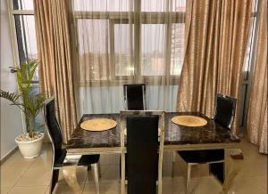 een eettafel en stoelen in een kamer met een raam bij Dream Land in Lagos
