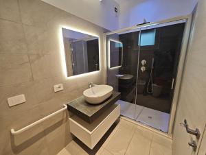 een badkamer met een wastafel en een douche bij Hotel Belvedere in Sottomarina +51 foto's