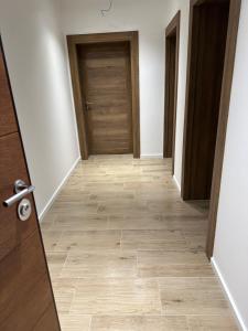 een lege hal met een deur en houten vloeren bij Happy moments Studio Kraljevo in Kraljevo