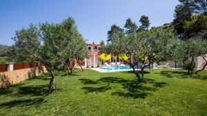 una casa con un cortile alberato e una piscina di Holiday home Ostojic by Villas Guide a Peračko Blato