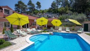 una piscina con ombrelloni e sedie gialli di Holiday home Ostojic by Villas Guide a Peračko Blato