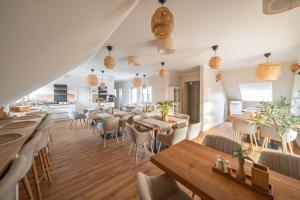 a restaurant with tables and chairs and a kitchen at Haus Lindolino in Elsterheide