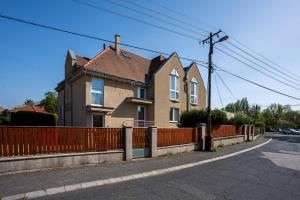 a house with a orange fence next to a street at B&B Lajta Park in Mosonmagyaróvár