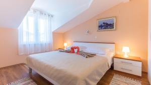 una camera da letto con un letto con un peluche rosso sopra di Holiday home Ostojic by Villas Guide a Peračko Blato Altre 30 foto