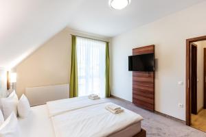 a bedroom with a bed and a flat screen tv at B&B Lajta Park in Mosonmagyaróvár +16 photos
