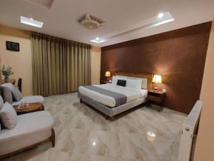 ein Hotelzimmer mit einem Bett und einer Couch in der Unterkunft Hotel Demanchi By The Leaf in Kārandūkai