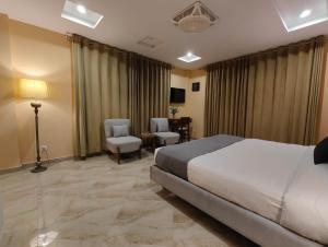 ein Hotelzimmer mit Bett, Tisch und Stühlen in der Unterkunft Hotel Demanchi By The Leaf in Kārandūkai