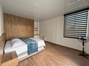 een slaapkamer met een bed, een bureau en een raam bij Casa boreales in Quimbaya