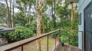 a balcony with a wooden railing and trees at Beautiful high-set studio close to beach in Ocean Shores