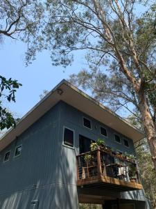 a house with a balcony on the side of it at Beautiful high-set studio close to beach in Ocean Shores