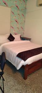 a bedroom with a bed in a room with a wallpaper at Le Green House Villa in Pondicherry