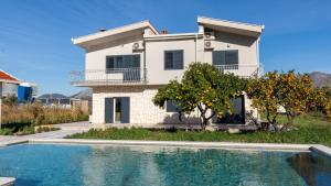 una casa con piscina di fronte a una casa di Villa Dolina Opuzen by Villas Guide a Podgradina