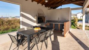 un patio con tavolo e sedie e una cucina di Villa Dolina Opuzen by Villas Guide a Podgradina