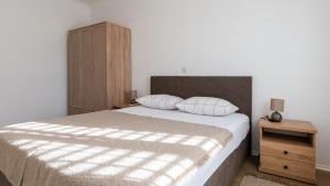 una camera da letto con un letto grande e un armadio in legno di Villa Dolina Opuzen by Villas Guide a Podgradina Altre 28 foto
