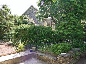un giardino con fiori e piante di fronte a una casa di Dol Llan - Hw7569 a Llangrannog