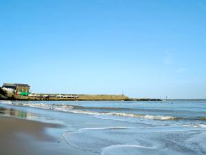 una spiaggia con l'oceano e un molo sullo sfondo di Dol Llan - Hw7569 a Llangrannog Altre 6 foto