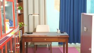 a desk with a chair in a room with blue curtains at Sunrise Komodo Homestay in Komodo +27 photos