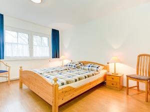 オストゼーバート・ゼリンにあるFerienwohnungen in Sellin D 091.020-25のベッドルーム(木製ベッド1台、椅子付)