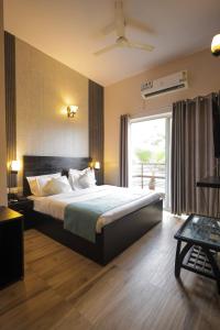 ein Schlafzimmer mit einem großen Bett und einem großen Fenster in der Unterkunft Nandan Retreat 4-Star Hotel & Luxury Villas Near Prem Mandir, Vrindavan in Vrindāvan