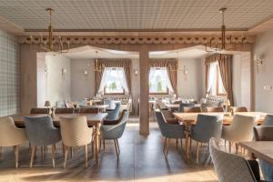 a restaurant with tables and chairs and windows at Willa Jędruś in Murzasichle