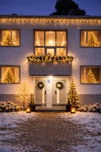 a house with christmasmas trees in front of it at Katariina Apartments in Kotka