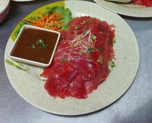 un piatto di alimenti con carne e verdure su un tavolo di Tropical Place a HUH Altre 23 foto