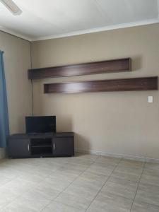 a living room with a tv and a table at Greenstone Guesthouse in Muldersdrift
